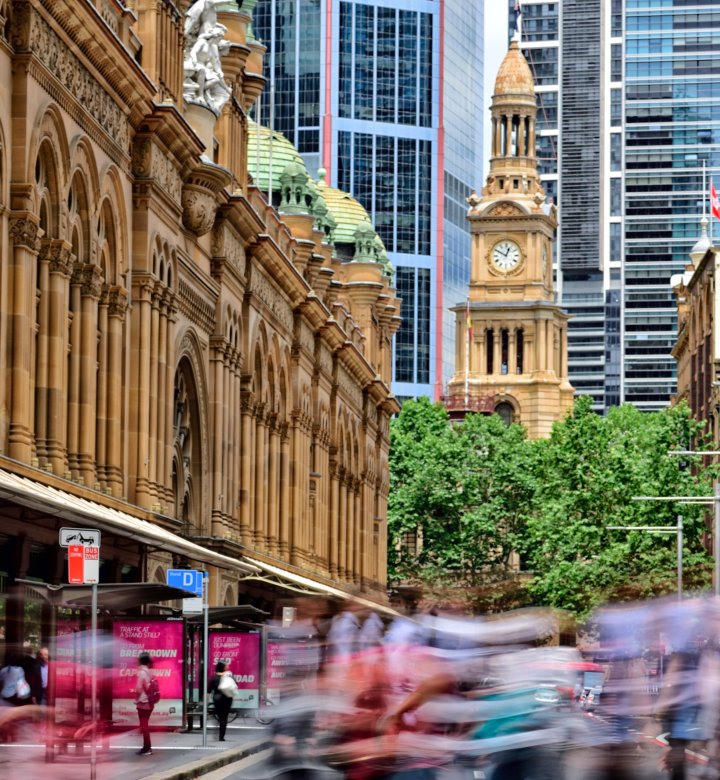 Street day scene of people walking Sydney CBD Queen Victoria Building and Sydney Town Hall Tower