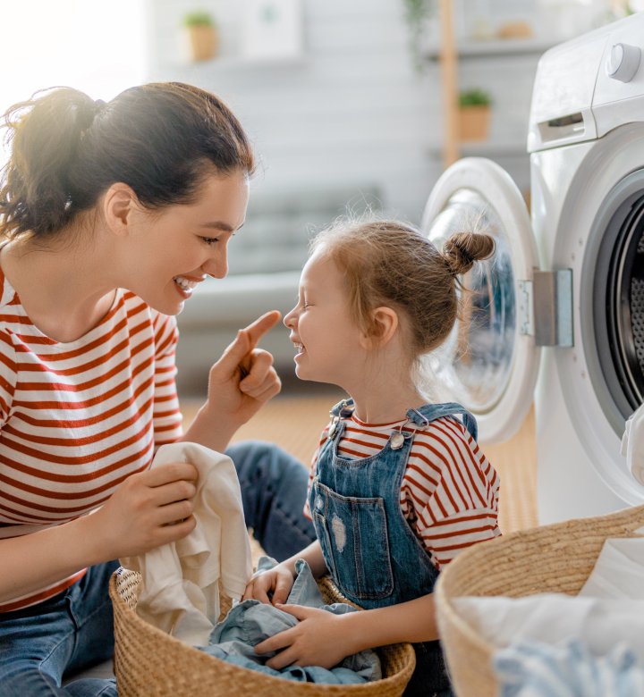 female adult with female child sorting laundry