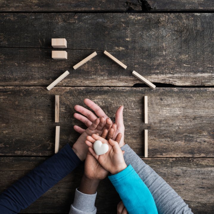 Family of four placing hands one on top