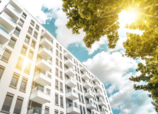 wide shot of an apartment block taken from ground level looking up to the sky